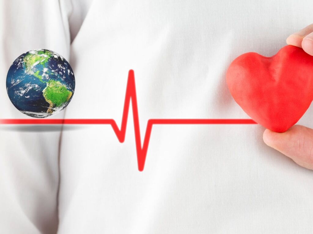 hay un mundo que representa las importaciones y esta unido a un corazón a través de un latido cardiaco, y detrás se ve una bata de un médico